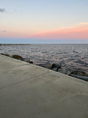 The flat surface of a concrete pier with a warm gray hue. A beautiful sunset on the Spanish coast. 2022.