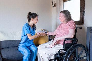 Nurse checking blood pressure of senior woman in wheelchair at home