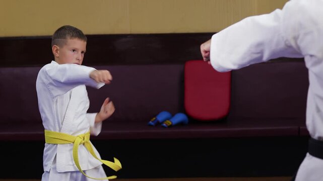 Two karategi athletes throw punches towards each other