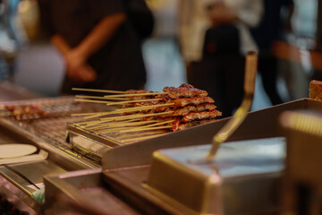 Authentic Japanese grilled eel sold on a stand at a fish market in Japan.