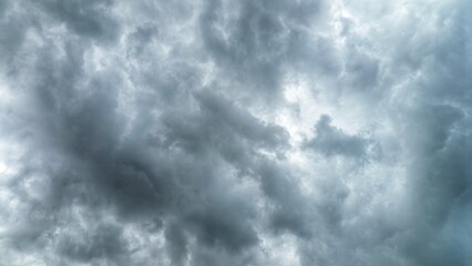 Dramatic, stormy clouds with a bright patch of sunlight breaking through the dark sky.