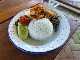 Tempong rice, Tempong rice is equipped with fresh vegetables, salted fish, eggs, chili sauce, tempeh, tofu and other accompaniments. Tempong rice is a typical food from Banyuwangi, Indonesia.