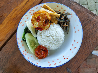 Tempong rice, Tempong rice is equipped with fresh vegetables, salted fish, eggs, chili sauce, tempeh, tofu and other accompaniments. Tempong rice is a typical food from Banyuwangi, Indonesia.