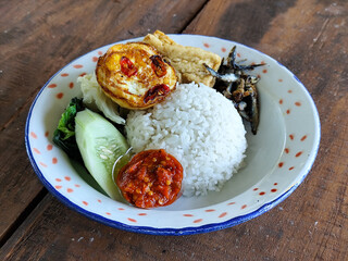 Tempong rice, Tempong rice is equipped with fresh vegetables, salted fish, eggs, chili sauce, tempeh, tofu and other accompaniments. Tempong rice is a typical food from Banyuwangi, Indonesia.