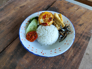 Tempong rice, Tempong rice is equipped with fresh vegetables, salted fish, eggs, chili sauce, tempeh, tofu and other accompaniments. Tempong rice is a typical food from Banyuwangi, Indonesia.