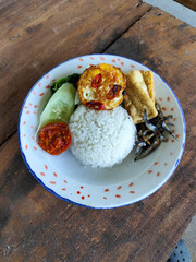 Tempong rice, Tempong rice is equipped with fresh vegetables, salted fish, eggs, chili sauce, tempeh, tofu and other accompaniments. Tempong rice is a typical food from Banyuwangi, Indonesia.