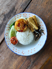 Tempong rice, Tempong rice is equipped with fresh vegetables, salted fish, eggs, chili sauce, tempeh, tofu and other accompaniments. Tempong rice is a typical food from Banyuwangi, Indonesia.