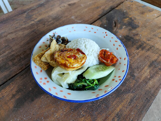 Tempong rice, Tempong rice is equipped with fresh vegetables, salted fish, eggs, chili sauce, tempeh, tofu and other accompaniments. Tempong rice is a typical food from Banyuwangi, Indonesia.