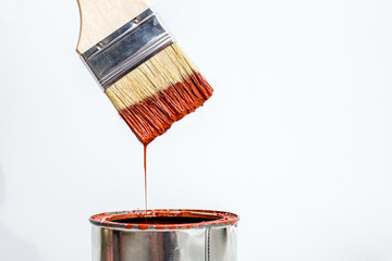 White plastic bucket with red color paint and brush on wood,vintage background