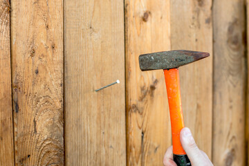 Panel wooden board designer people person concept. Side profile close up photo portrait of serious concentrated guy hammering nail into wall hold metallic tool equipment instrument