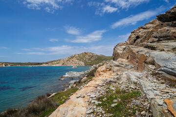 Rocky, hilly and lush landscape and the Aegean Sea at the Paros Park on Paros island in Greece on a sunny day.