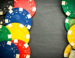 Colorful poker chips arranged on dark slate