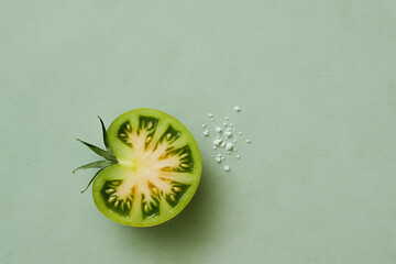 Half Green Tomato with Salt on Sage Green Background, Top View