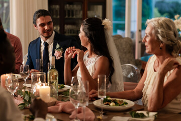 Bride and groom sharing joyful conversation with guests at elegant wedding dinner