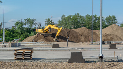 An excavator is working on a construction site. Road construction. Crawler excavator and...