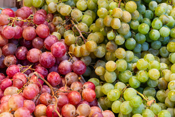 A close-up of plump, fresh red and green grapes displayed at a fruit stall in Mercado de la Ribera, Bilbao, highlighting the market’s abundance and natural beauty.

