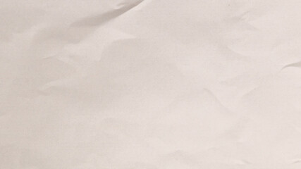 A piece of crumpled white paper lays on a flat surface, showcasing its soft texture and gentle...