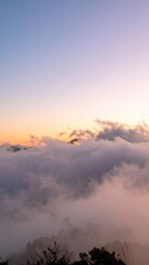 Fototapeta premium Aerial View of Mountains Covered in Clouds at Sunrise with Golden Sky and Soft Light