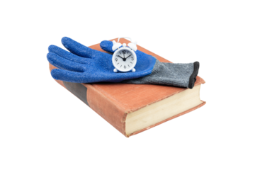 Blue work glove rests on a book with a small alarm clock on top of it, isolated on white background with clipping path.