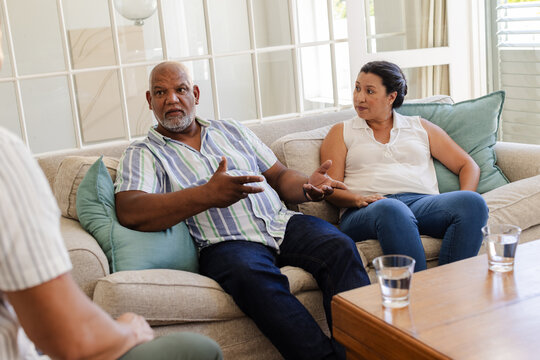 Senior couple discussing important matters while sitting on living room sofa