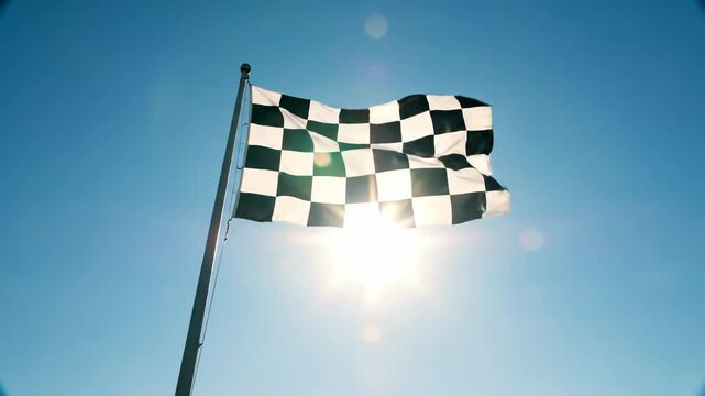 Checkered Flag Waving Against Bright Blue Sky