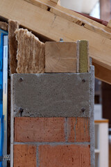 A cutaway view shows the different layers of a building's wall and roof, including brick, concrete,...