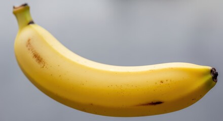 Close-up of a single ripe banana against a neutral background