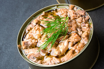 Canned tuna in brine isolated on black  background