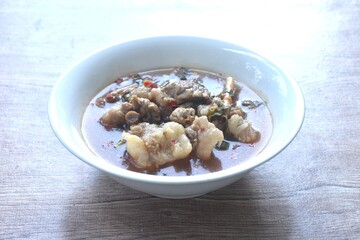 boiled slice braised beef meat with chili in clear tom yum soup on bowl 