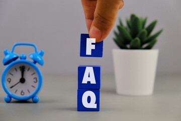 text of FAQ acronym of frequently asked question on management and business concept on blue block 