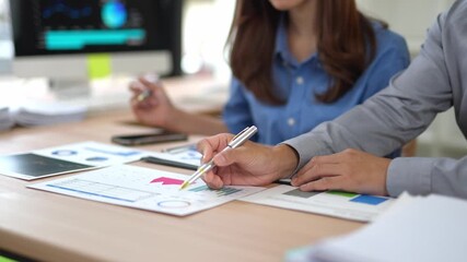 Professional business team analyzing financial performance, reviewing data driven charts and graphs while collaborating on strategic planning in modern corporate office setting - Powered by Adobe