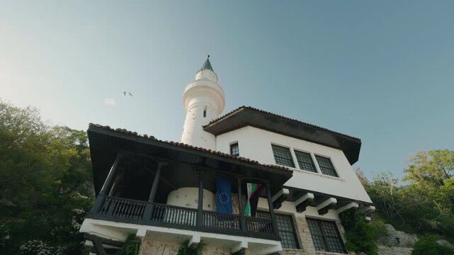 Balchik, Bulgaria, 15 August 2025: Historic Balchik Palace with white tower and minaret surrounded by greenery in Bulgaria