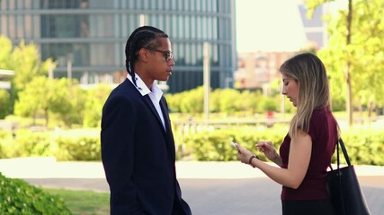 Business partners discussing and using smartphones in the financial district - Powered by Adobe