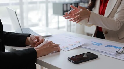 Professional business team collaborating on financial analysis, reviewing charts and graphs while strategizing company investment approaches in modern office setting