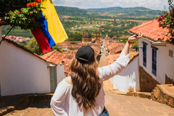 Young Caucasian Latina woman enjoying the scenic view of Barichara, Colombia, a famous colonial town known for its cobblestone streets, travel, cultural tourism, heritage, adventure and exploration