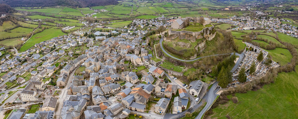 An aerial panoramic view around the old town of the city Sévérac-d'Aveyron in France on a sunny day in early spring