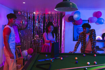 Naklejka premium Teens enjoying pool game at vibrant party with colorful balloons and decorations