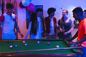 Naklejka premium Teenagers enjoying lively pool game at home party with colorful decorations