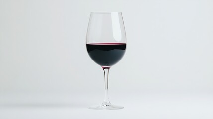 A classic red wine glass filled halfway with dark red wine against a minimalist background, Perfect for use in articles, menus, or advertisements related to wine, dining, and celebrations,