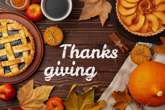 Thanksgiving celebration with pies, apples, and autumn leaves on wooden table