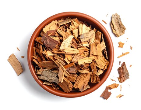 Fragrant quassia amara bark chips presented in a terracotta bowl, isolated view