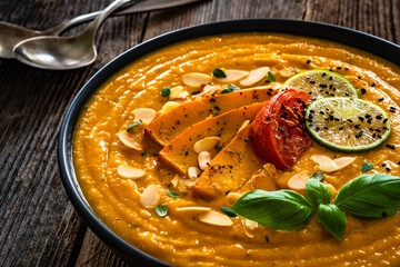 Pumpkin cream soup on wooden table	