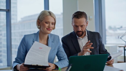 Successful employees chatting online looking laptop at agency office closeup