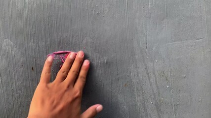 Hand wipes a paper heart on a wall until it fades away, creating a poignant visual for a broken heart theme background, 4K footage