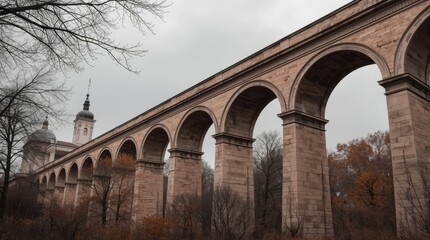 Obraz premium Majestic stone aqueduct arches in an autumn landscape under a cloudy sky