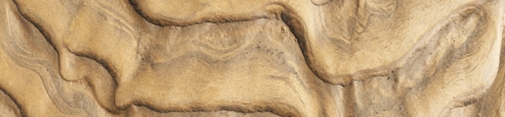 Close-up of natural sand ripple texture formed by wind and water. Abstract background with wavy layered patterns in warm beige and golden tones, ideal for use in design, texture, and creative backgrou