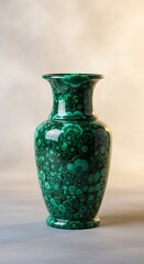A striking, emerald green malachite vase displays intricate circular patterns, showcasing the natural beauty of the stone.