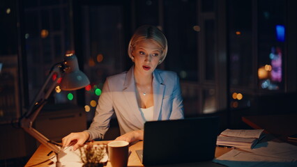 Successful employee talking virtual conference at dark office. Smiling blonde