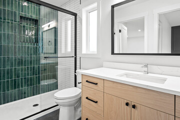 Bathroom with a green tile wall and a white toilet