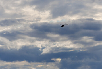 Military helicopter flying through dramatic cloudy sky